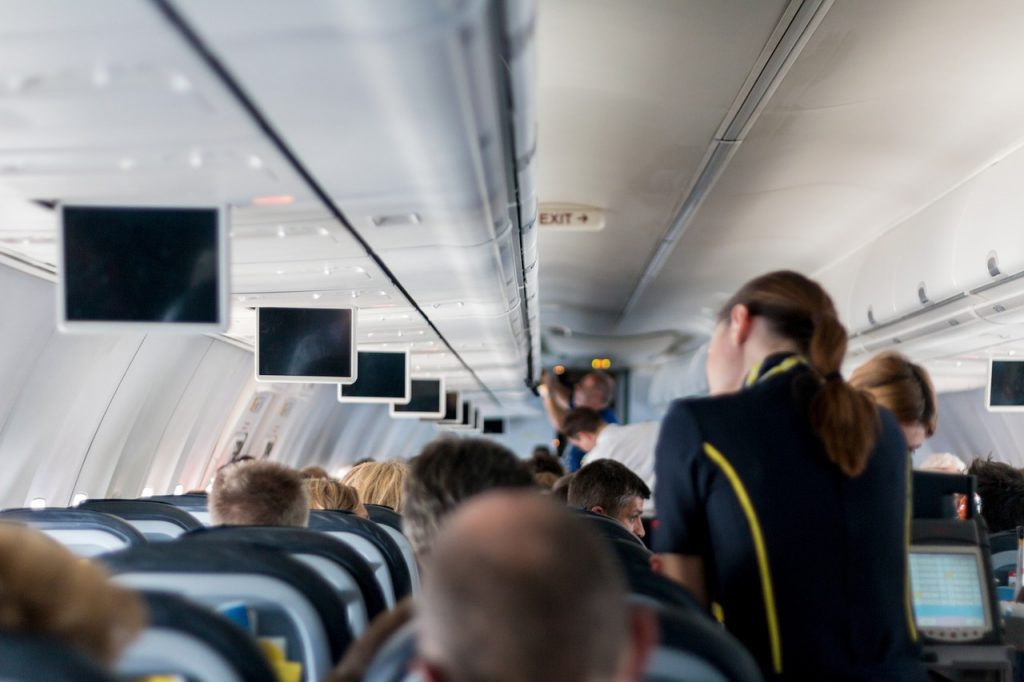 Flygvärdinna som tar hand om passagerare på ett flygplan